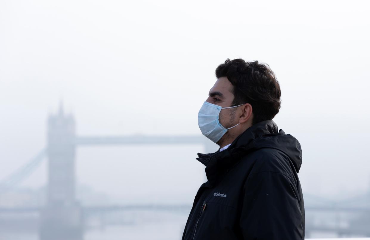 LONDON, Nov. 5, 2020 -- A man wearing a face mask walks on the London Bridge backdropped by the Tower Bridge shrouded in fog in London, Britain, on Nov. 5, 2020. British lawmakers on Wednesday voted in favor of the government's a month-long lockdown for England by 516 votes to 38, a majority of 478.    The vote outcome paved the way for the new measures, announced by British Prime Minister Boris Johnson on Saturday in a bid to quell the surging coronavirus infections. (Photo by Han Yan/Xinhua via Getty) (Xinhua/Han Yan via Getty Images)