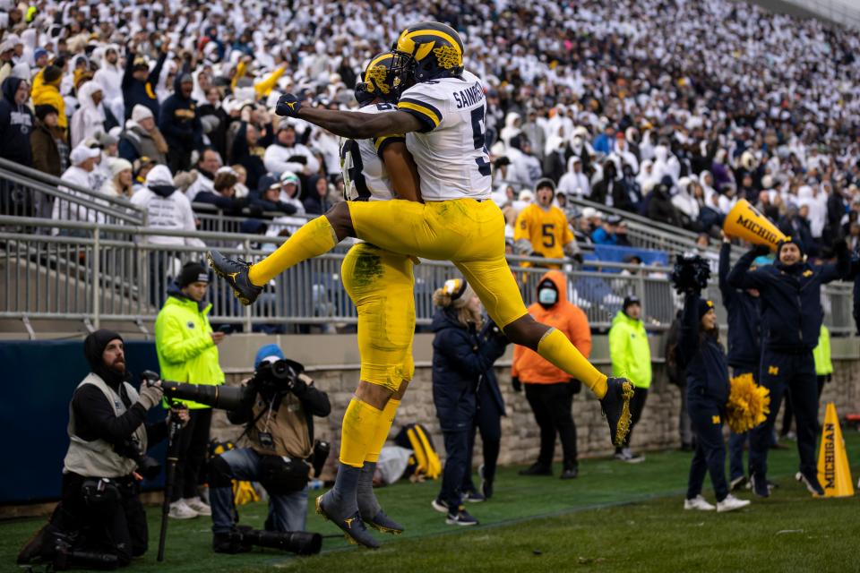 Erick All, left, celebrates with Mike Sainristil after scoring the winning touchdown against Penn State at Beaver Stadium on Nov. 13, 2021 in State College, Pennsylvania.