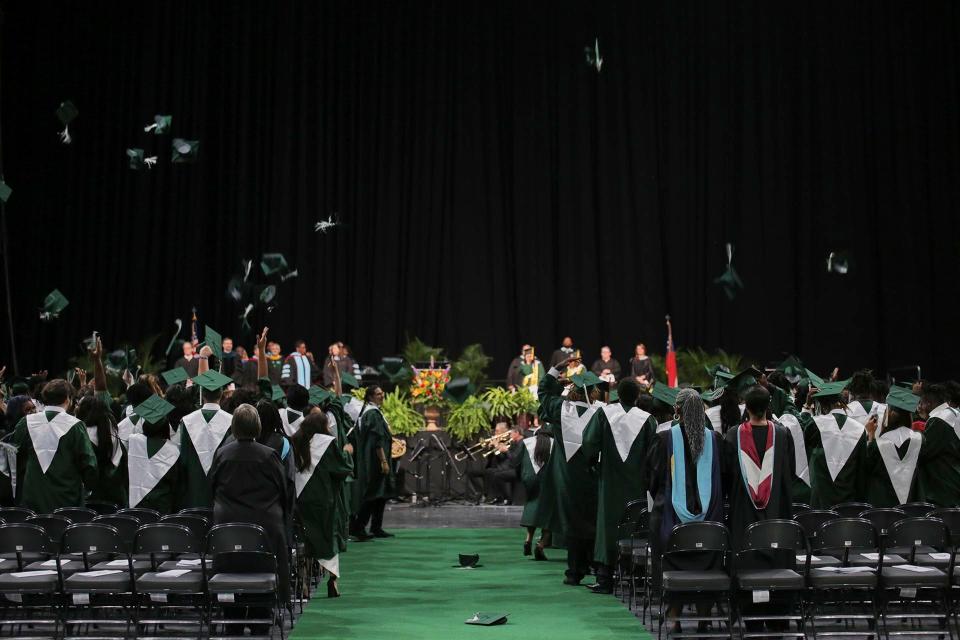 Windsor Forest graduates throw their caps in the air to celebrate their graduation on Tuesday at the enmarket Arena.