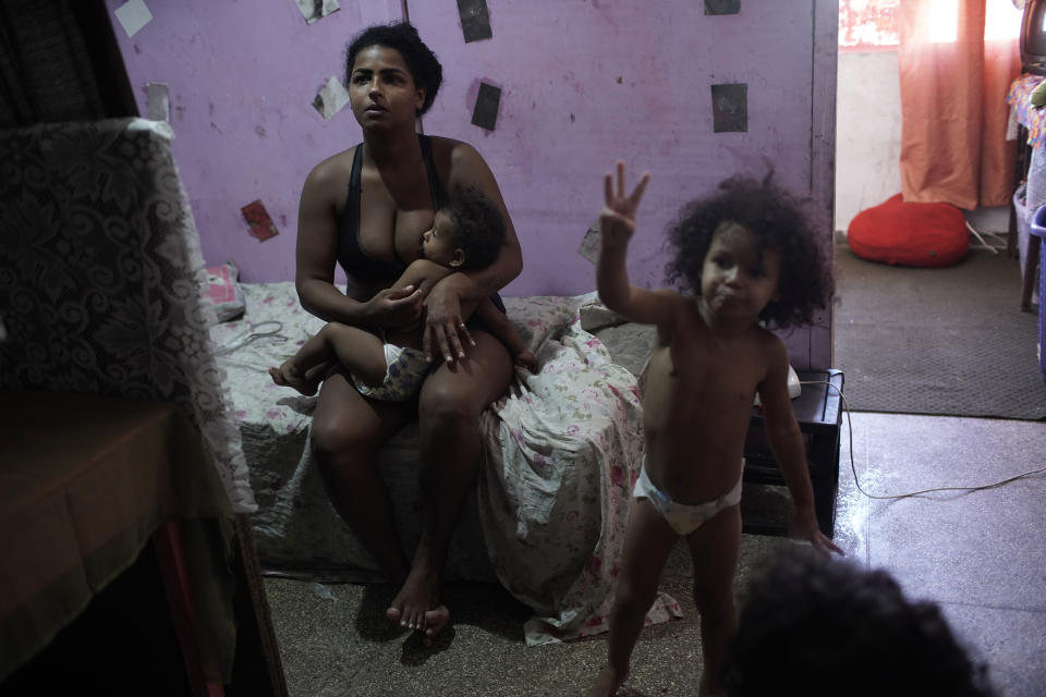 Thayane, who used to make a living as a manicurist, breastfeeds her one-year-old daughter Mirella in their room of an occupied building where she lives with her three daughters, in Rio de Janeiro, Brazil, Thursday, March 11, 2021. Before the coronavirus pandemic hit Thayane had steady work as a manicurist, riding her bike to clients’ homes or receiving walk-ins at the squat. (AP Photo/Silvia Izquierdo)