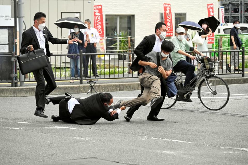 <div class="inline-image__caption"><p>The suspect in the assassination of former Japanese Prime Minister Shinzo Abe is tackled by police officersin Nara.</p></div> <div class="inline-image__credit">Asahi Shimbun via Reuters</div>