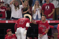 Los Angeles Angels' Mike Trout, right, puts a cowboy hat on Shohei Ohtani after Ohtani hit a solo home run during the third inning of a baseball game against the Seattle Mariners Saturday, June 25, 2022, in Anaheim, Calif. (AP Photo/Mark J. Terrill)