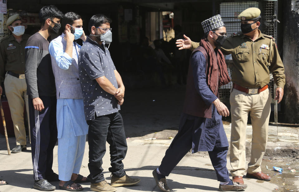 Indian passengers who got stranded at a bus terminal line up for free food being distributed by shop keepers during a day long lockdown amid growing concerns of coronavirus in Jammu, India, Sunday, March 22, 2020. India is observing a 14-hour “people's curfew” called by Prime Minister Narendra Modi in order to stem the rising coronavirus caseload in the country of 1.3 billion. For most people, the new coronavirus causes only mild or moderate symptoms. For some it can cause more severe illness. (AP Photo/Channi Anand)