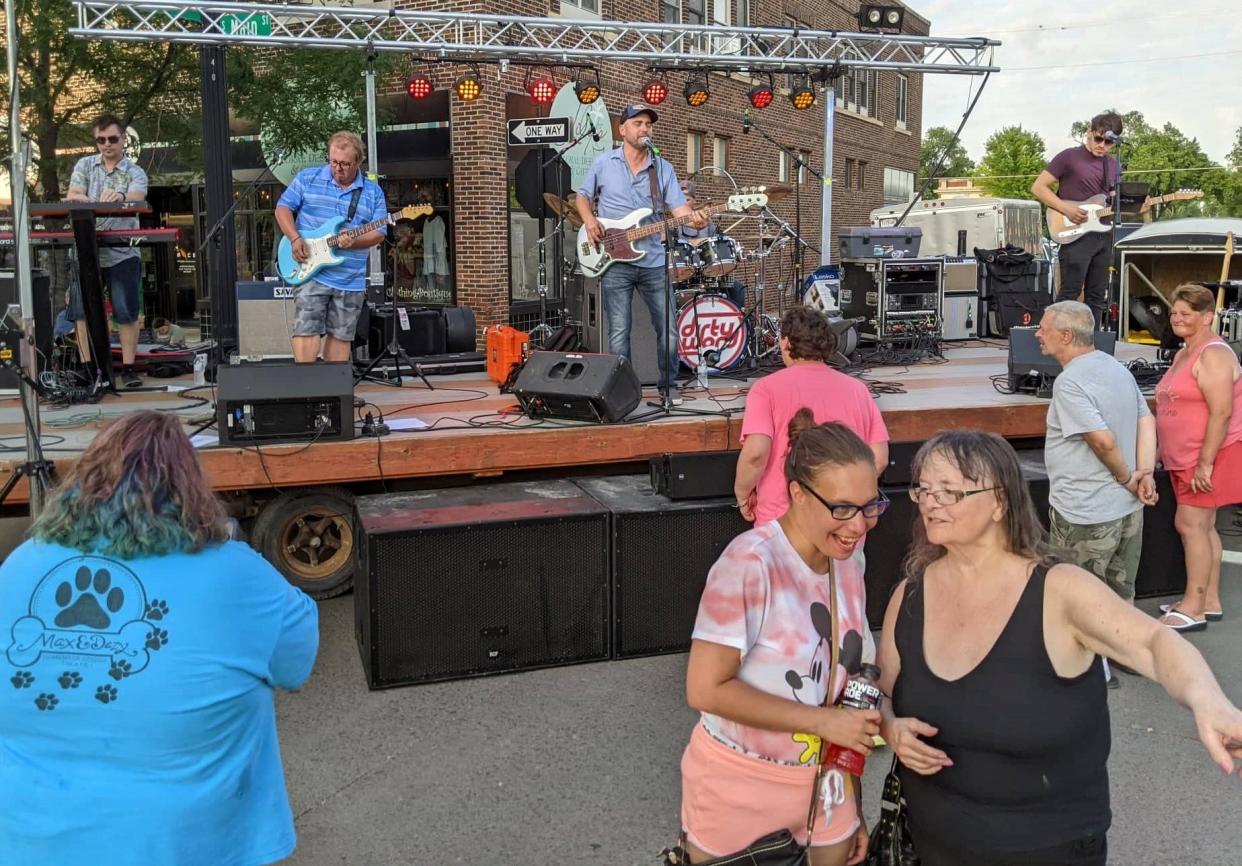 Fans gather near the stage as John Scalia & The Dirty Word begin Thursday night's downtown summer concert at Malchow Plaza.