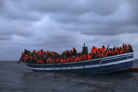 Migrants are seen onboard a drifting overcrowded wooden boat, during a rescue operation by the Spanish NGO Proactiva Open Arms, north of the Libyan city of Sabratha in central Mediterranean Sea, March 29, 2017. REUTERS/Yannis Behrakis