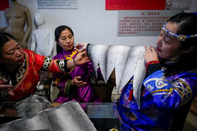 Ethnic Hezhen You Wenfeng's Chinese Han students learn how to make clothes from fish skin at You's studio in Tongjiang