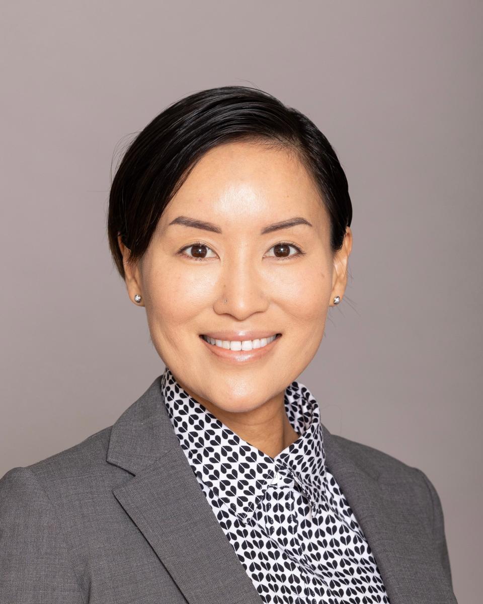 Akina Harada, founder of Abunai Poke in Washington, DC, poses for a photo while wearing a grey blazer and black-and-white collared shirt