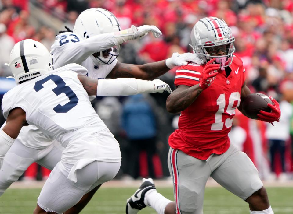 Oct 21, 2023; Columbus, Ohio, USA; Ohio State Buckeyes running back Chip Trayanum (19) runs the ball against Penn State Nittany Lions linebacker Curtis Jacobs (23) during the fourth quarter of their game at Ohio Stadium.