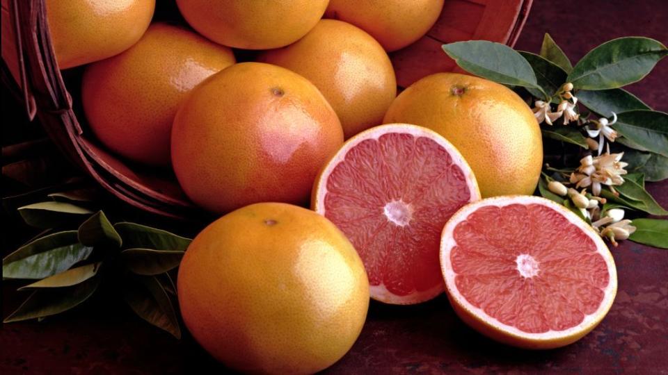 grapefruits in basket with cut fruit halves
