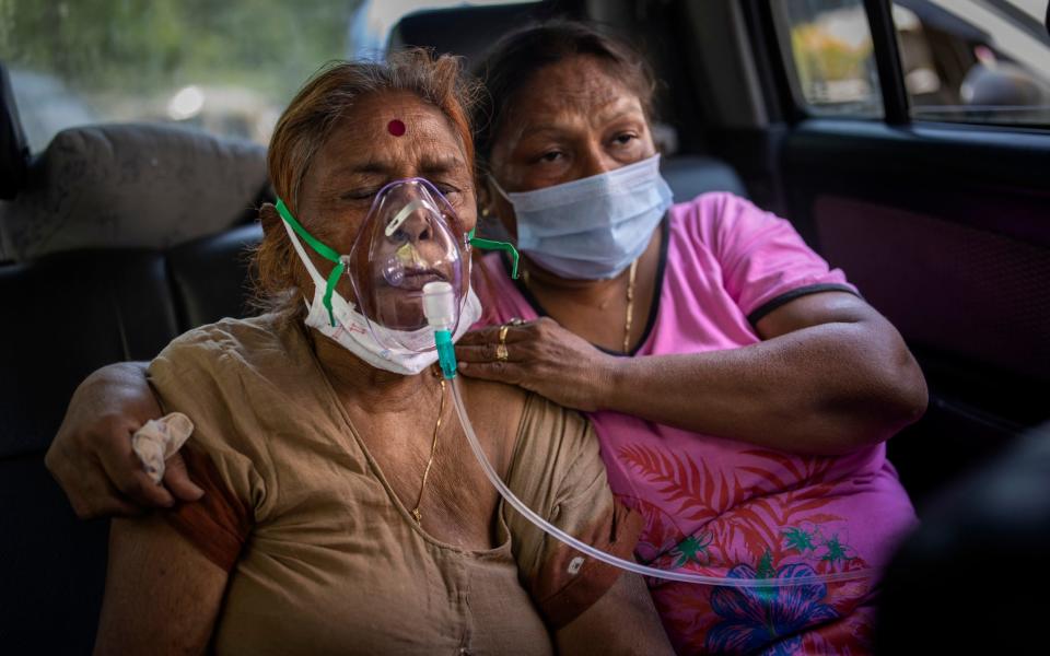 A Covid patient receives oxygen inside a car provided by a Gurdwara, a Sikh house of worship, in New Delhi - Altaf Qadri/AP