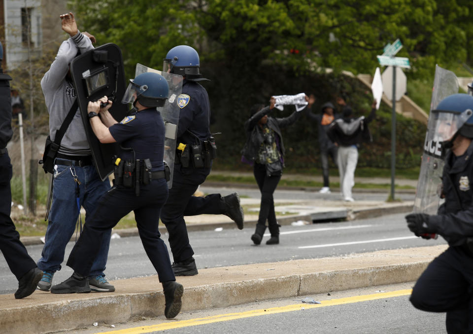 Baltimore Police officers  push back a protestor on Reisterstown Road near Mowdamin Mall, April 27, 2015 in Baltimore, Maryland. The funeral service for Freddie Gray, who died last week while in Baltimore Police custody, was held on Monday morning. (Photo by Drew Angerer/Getty Images)