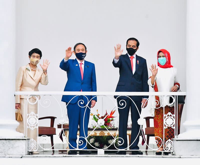 Japan's PM Suga, Indonesian President Widodo and their wives wave during a visit at Indonesian Presidential Palace in Bogor