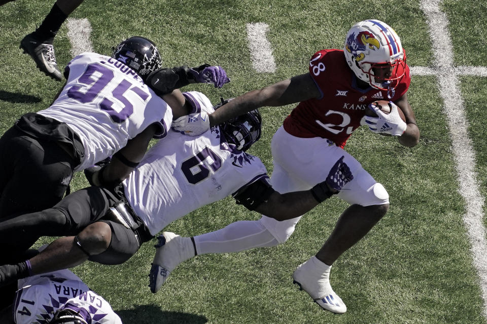 Kansas running back Sevion Morrison (28) gets past TCU linebacker Jamoi Hodge (6) during the first half of an NCAA college football game Saturday, Oct. 8, 2022, in Lawrence, Kan. (AP Photo/Charlie Riedel)