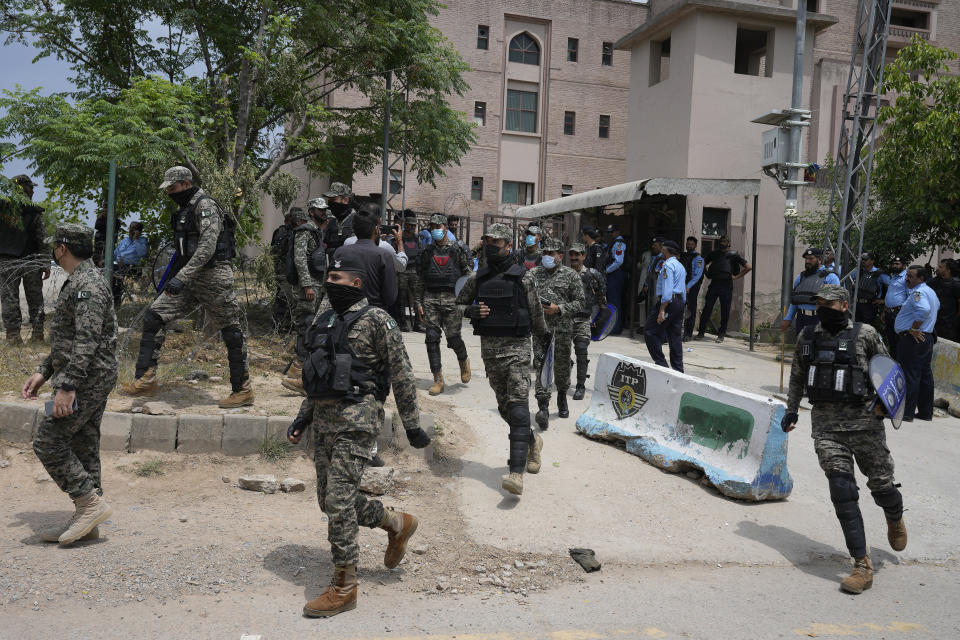 Paramilitary troops and police officers stand guard outside a court where Pakistan's former Prime Minister Imran Khan is appeared in Islamabad, Pakistan, Tuesday, May 23, 2023. Khan on Tuesday pressed his legal battle before a court in the capital, Islamabad, which granted him protection from arrest until early next month in several cases where he faces terrorism charges for inciting violence. (AP Photo/Anjum Naveed)