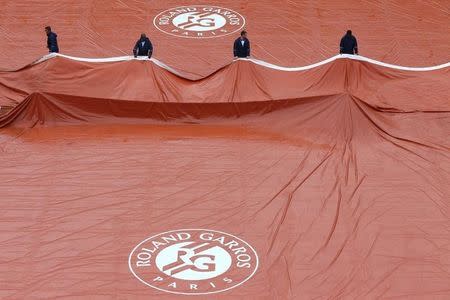 Tennis - French Open - Roland Garros - Paris, France - 22/05/16 Court workers remove tarpaulin after rain. REUTERS/Pascal Rossignol