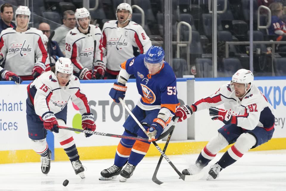 New York Islanders center Casey Cizikas (53) skates between Washington Capitals center Evgeny Kuznetsov (92) and left wing Sonny Milano (15) during the second period of an NHL hockey game Saturday, March 11, 2023, in Elmont, N.Y. (AP Photo/Mary Altaffer)