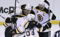 Boston Bruins right wing Jarome Iginla, center, is mobbed by teammates as they celebrate their 3-2 overtime win in Game 4 of a first-round NHL hockey playoff series against the Detroit Red Wings in Detroit, Thursday, April 24, 2014. Iginla was credited with the winning goal. (AP Photo/Carlos Osorio)