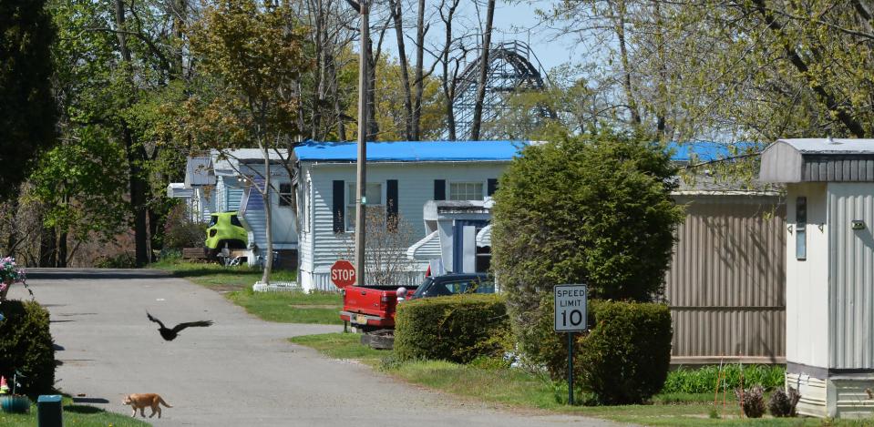 A street at Village Mobile Home Park is shown in Millcreek Township on May 6, 2023. The top of the Ravine Flyer roller coaster at Waldameer Park & Water World can be seen in the background.