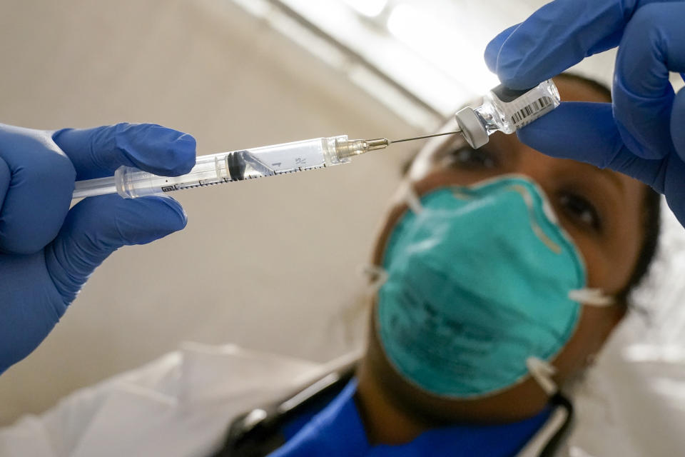 FILE - In this Jan. 15, 2021, file photo, Dr. Yomaris Pena, Internal Medicine Physician with Somos Community Care at a COVID-19 extracts the last bit of Pfizer-BioNTech COVID-19 Vaccine out of a vial so as not to waste it at a vaccination site at the Corsi Houses in the East Harlem neighborhood of New York. An increasing number of COVID-19 vaccination sites around the U.S. are canceling appointments because of vaccine shortages in a rollout so rife with confusion and unexplained bottlenecks. (AP Photo/Mary Altaffer, File)