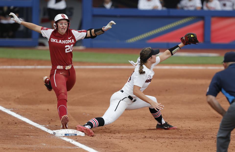 Georgia infielder Ellie Armistead (24) makes the catch at first base before Oklahoma's Jana Johns (20) runs across in the second inning of an NCAA Women's College World Series softball game on Saturday, June 5, 2021, in Oklahoma City. (AP Photo/Alonzo Adams)