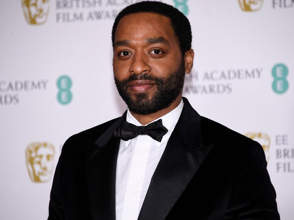 Chiwetel Ejiofor wears a black suit and black bowtie at the BAFTAs in April 2021.