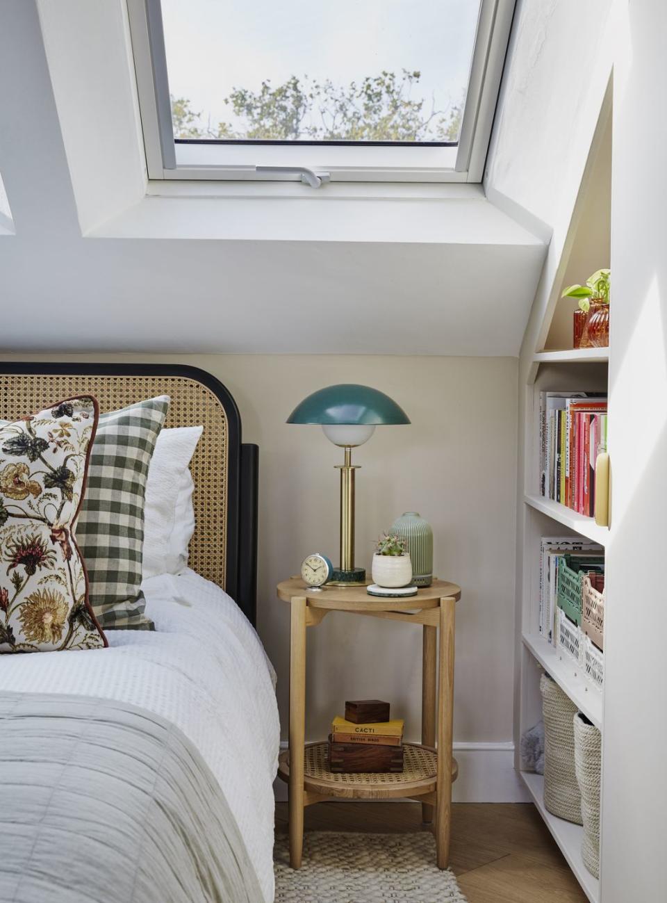 rattan bed frame with wooden bedside table under the eaves with bookshelf built in