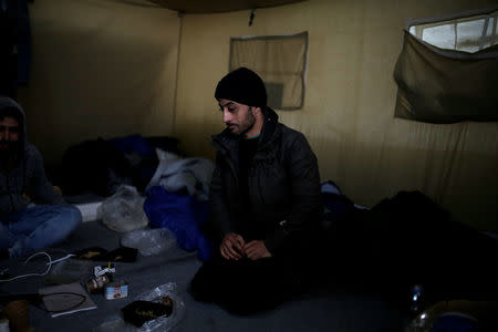 Syrian refugee Essa Alsheikh Ahmed, 29, sits inside his tent at a makeshift camp for refugees and migrants next to the Moria camp on the island of Lesbos, Greece, November 30, 2017. REUTERS/Alkis Konstantinidis