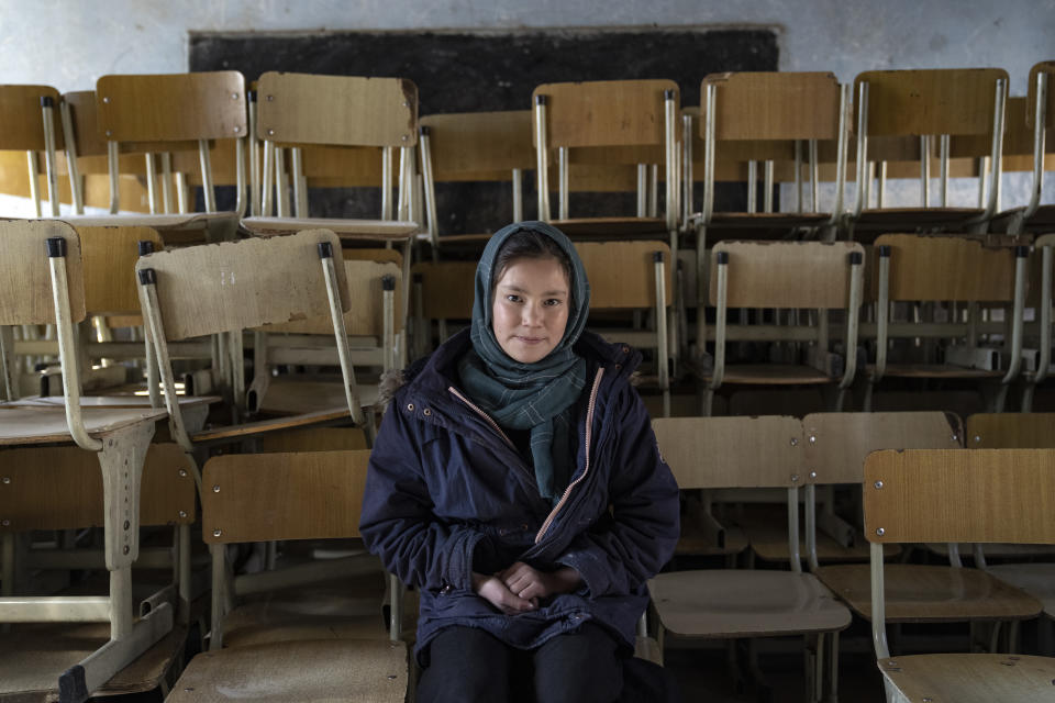 Halimah, 13-year-old schoolgirl, poses for a photo in an empty classroom in Kabul, Afghanistan, Thursday, Dec. 22, 2022. The country's Taliban rulers earlier this week ordered women nationwide to stop attending private and public universities effective immediately and until further notice. They have banned girls from middle school and high school, barred women from most fields of employment and ordered them to wear head-to-toe clothing in public. Women are also banned from parks and gyms.(AP Photo/Ebrahim Noroozi)