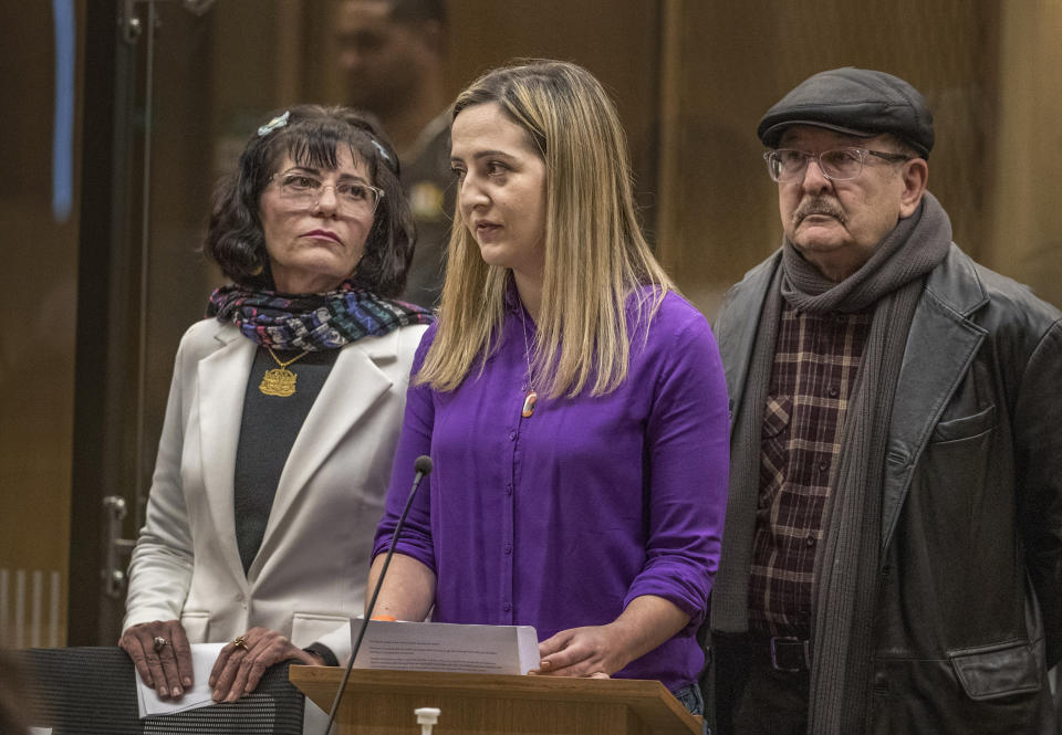 Aya Al-Umari, center, stands at a podium during her victim impact statement