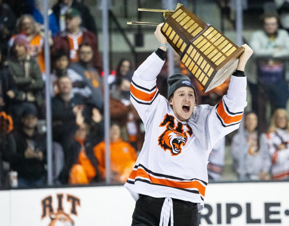 RIT's Carter Wilkie raises the Atlantic Hockey championship trophy after the Tigers defeated American International, 5-2, in the conference title game Saturday, March 23 at the Gene Polisseni Center.