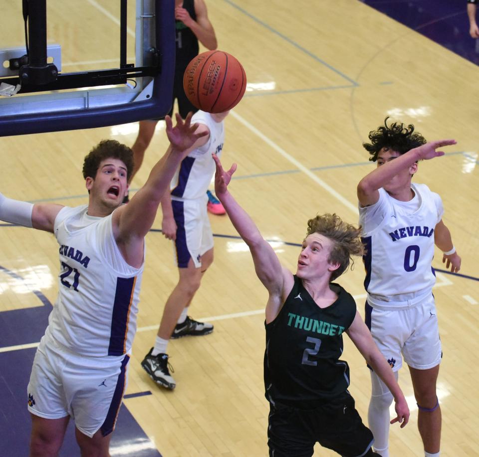 Nevada's Carson Rhodes (21) and Jacob Khounsourath (0) come up to block a shot by Grand View Christian's Josh Sanderson during the first quarter of the Cubs' 72-57 loss to the No. 1 team in Class 1A Feb. 2 at the Nevada High School Field House in Nevada.