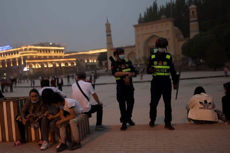 Police officers patrol the square in front of Id Kah Mosque in Kashgar