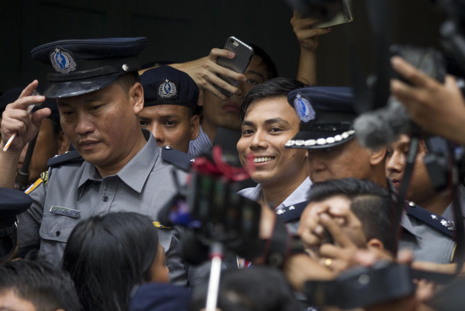 Reuters journalist Kyaw Soe Oo, center, is escorted by police as he leaves the court Monday, Sept. 3, 2018, in Yangon, Myanmar. The court sentenced two Reuters journalists to seven years in prison Monday for illegal possession of official documents, a ruling that comes as international criticism mounts over the military's alleged human rights abuses against Rohingya Muslims. (AP Photo/Thein Zaw)