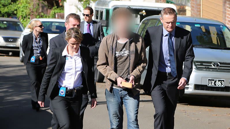 Daniel Kelsall clutches a sci-fi novel after being arrested on Tuesday over the stabbing death of Morgan Huxley. Photo: NSW Police Media