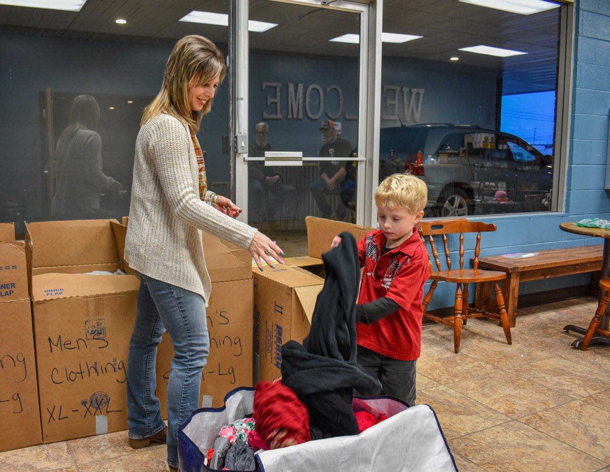 Heather Brooks gets help from her son, Brenden Brooks, as she packs clothes donated for victims of the Jan. 19 Blossom Healthcare fire. The facility needs no more clothes, but Brooks is still collecting personal care items and arts supplies. Lake Point Baptist Church is the drop-off point.
