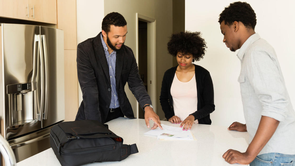 Couple talking to broker in new house.