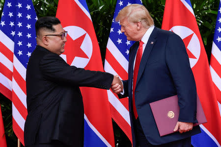 FILE PHOTO - U.S. President Donald Trump and North Korea's leader Kim Jong Un shake hands during the signing of a document after their summit at the Capella Hotel on Sentosa island in Singapore June 12, 2018. Susan Walsh/Pool via Reuters/File Photo