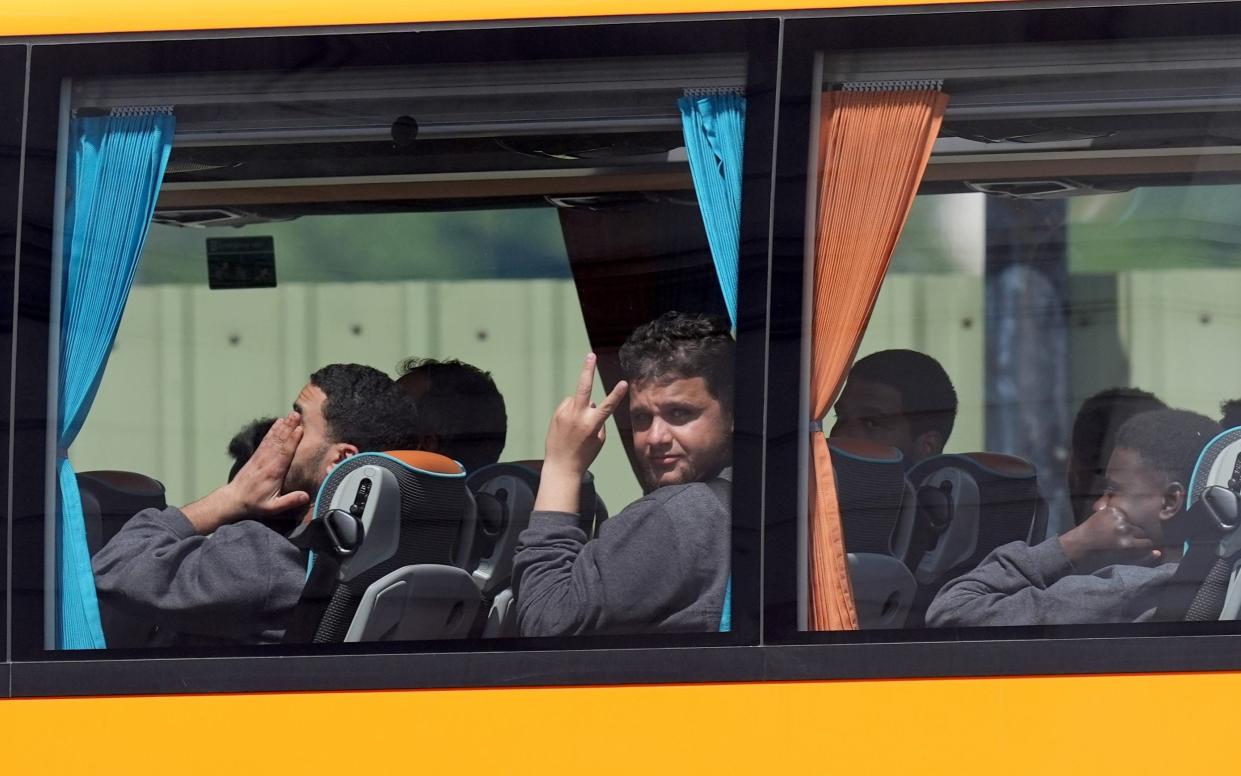 People believed to be migrants leaving by bus from the Border Force compound in Dover, Kent today