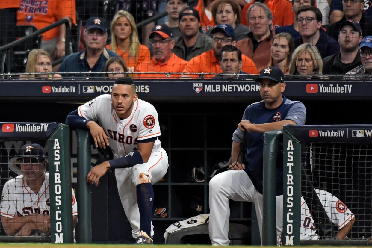 Carlos Correa #1 and hitting coach Alex Cora #26 of the Houston Astros look on from the dugout during Game 3 of the 2017 World Series against the Los Angeles Dodgers at Minute Maid Park on Friday, October 27, 2017 in Houston, Texas.