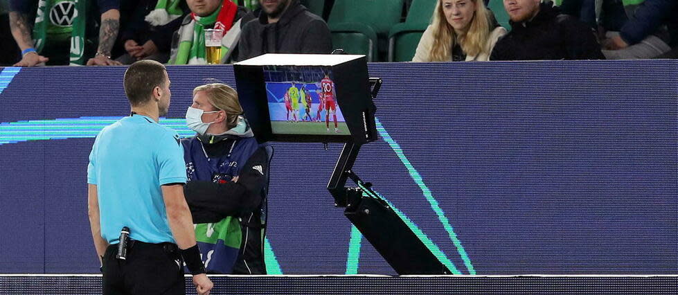 Georgi Kabakov, arbitre bulgare, consulte l'assistance vidéo en bord de terrain lors du match entre le VfL Wolfsburg et le FC Séville le 29 septembre 2021.
