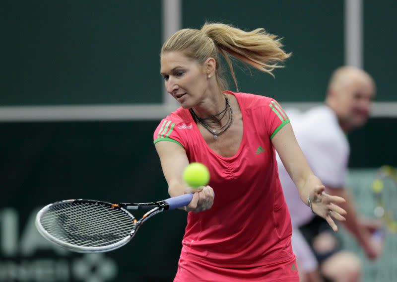 FILE PHOTO: Germany's Graf and husband Agassi of U.S. are pictured during their mixed doubles exhibition tennis match in Prague