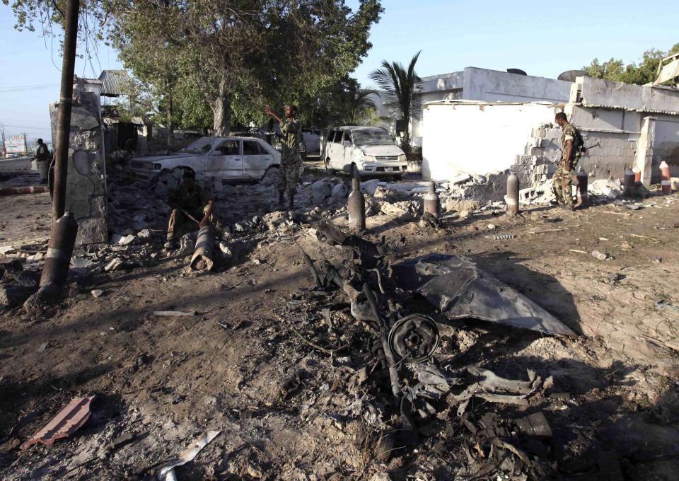 Soldiers assess the aftermath at the scene of an explosion outside the Jazira hotel in Mogadishu