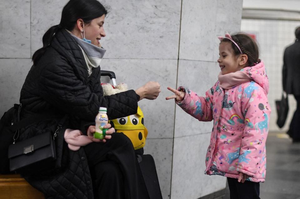 <p>Le chaos n'est pas loin, mais cette mère de famille occupe sa fille en jouant avec elle à pierre-feuille-ciseaux, en attendant sans doute de se mettre à l'abri de potentiels bombardements. (Daniel LEAL / AFP)</p> 