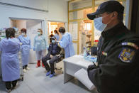 In this photo taken on Friday, Jan. 15, 2021 a Romanian gendarme waits to get a COVID-19 vaccine at a hospital in Bucharest, Romania. Across the Balkans and the rest of the nations in the southeastern corner of Europe, a vaccination campaign against the coronavirus is overshadowed by heated political debates or conspiracy theories that threaten to thwart the process. In countries like the Czech Republic, Serbia, Bosnia, Romania and Bulgaria, skeptics have ranged from former presidents to top athletes and doctors. Nations that once routinely went through mass inoculations under Communist leaders are deeply split over whether to take the vaccines at all. (AP Photo/Vadim Ghirda)