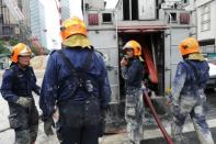 Singapore Civil Defense Force personnel prepare to pump water to softhen wet cement at the construction site of the new Downtown Line (DTL) Bugis Station subway in Singapore on July 18, 2012. Two workers were killed and eight others injured when the scaffolding at a subway construction site collapsed