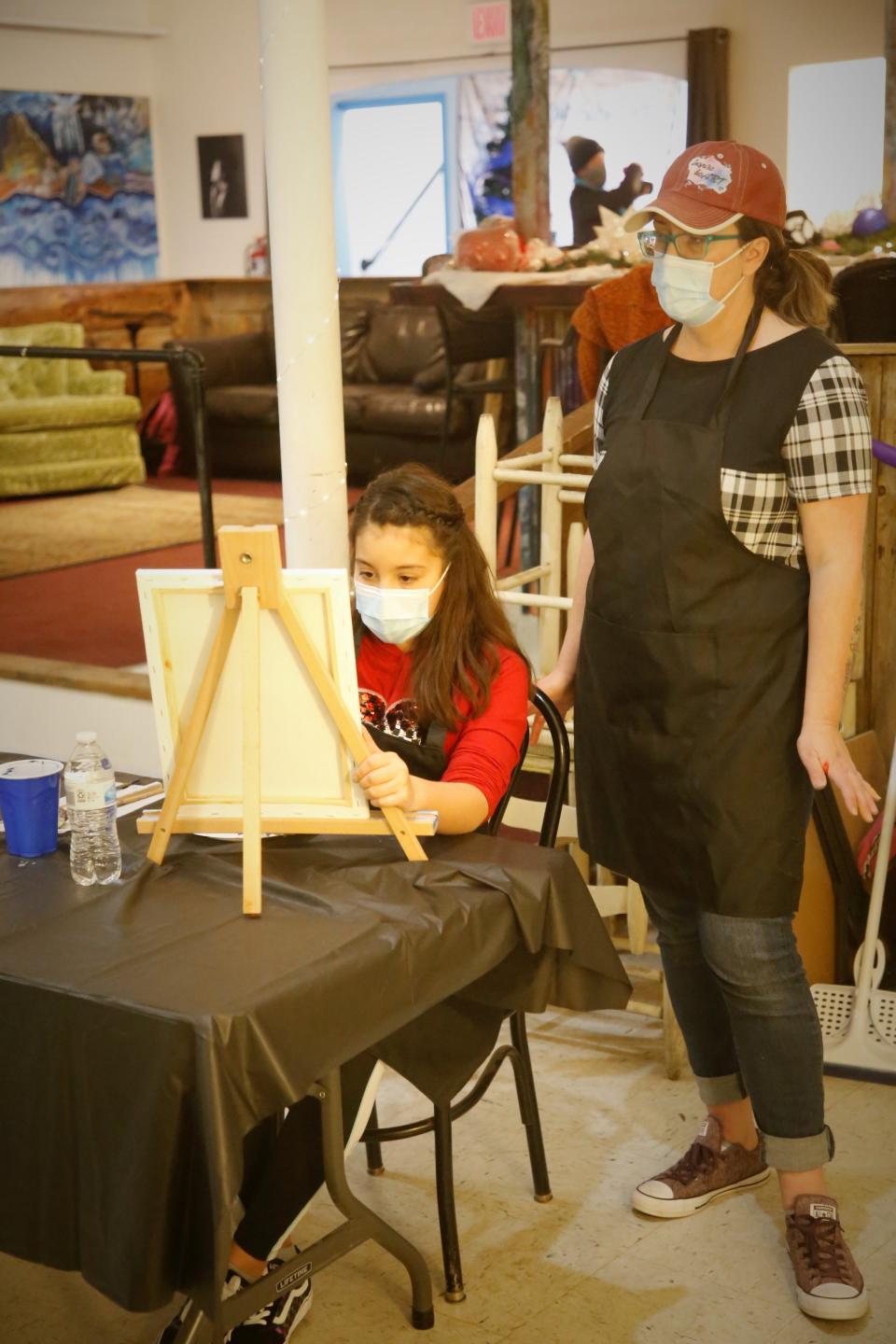 Christy Clugston of Inspire HeArt works with a student during a December 2020 painting class at the organization's headquarters at the Aztec Theater in Aztec.