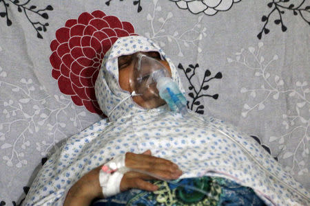 A woman breathes through an oxygen mask at al-Quds hospital, after a hospital and a civil defence group said a gas, what they believed to be chlorine, was dropped alongside barrel bombs on a neighbourhood of the Syrian city of Aleppo, Syria, early August 11, 2016. REUTERS/Abdalrhman Ismail