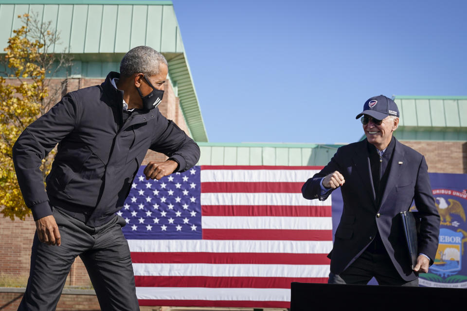 Barack Obama and Joe Biden greet each other with an elbow tap at a campaign event in Michigan on Sunday.