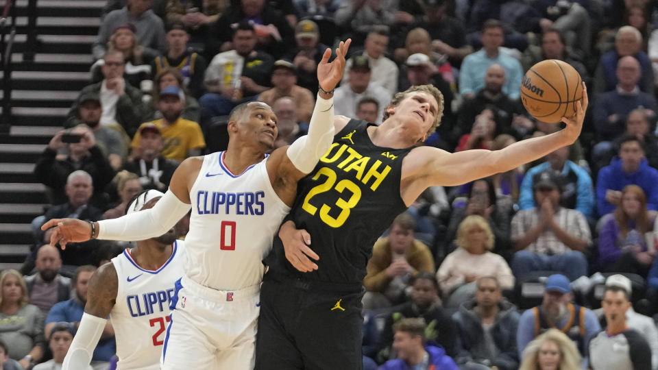 Utah Jazz forward Lauri Markkanen (23) and Los Angeles Clippers guard Russell Westbrook (0) reach for the ball during the second half of an NBA basketball game Friday, Oct. 27, 2023, in Salt Lake City. (AP Photo/Rick Bowmer)