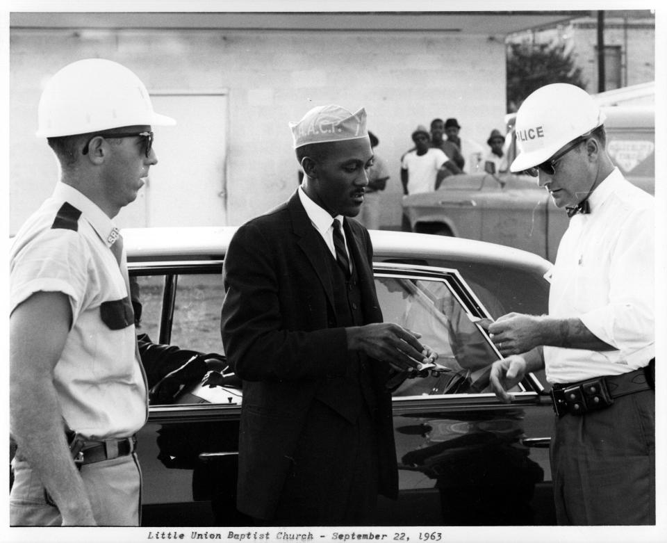 Just hours before he was severely beaten, the Rev. Harry Blake talks with Shreveport police outside a memorial service at the Little Union Baptist Church on Sept. 22, 1963. Local authorities refused a permit to hold a memorial for four girls killed in a bomb blast in Birmingham, Ala., several days earlier. When people showed up at the church and it appeared a march would be held anyway, a tense confrontation ensued.